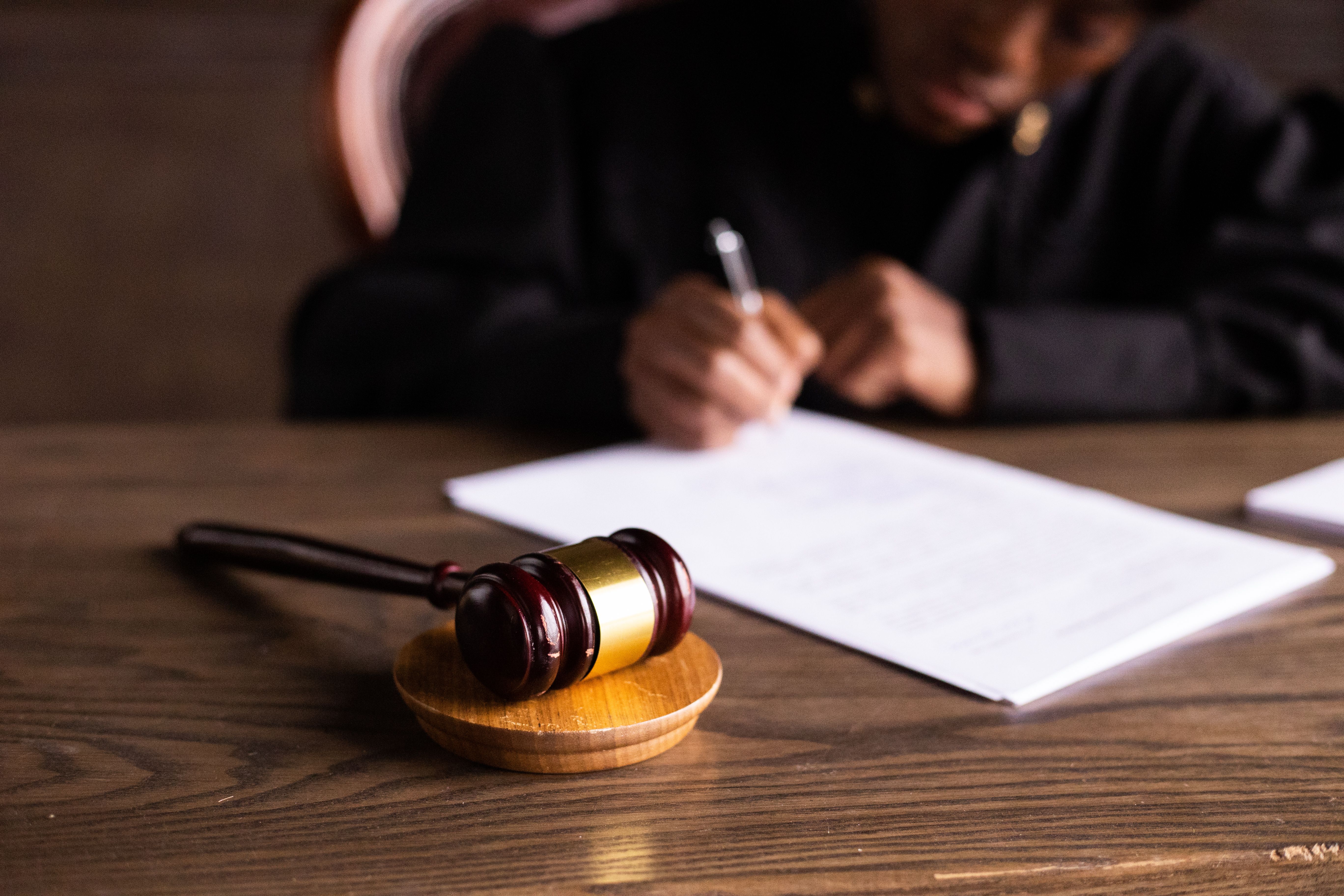 Judge signing a court ruling with a gavel in a group litigation case