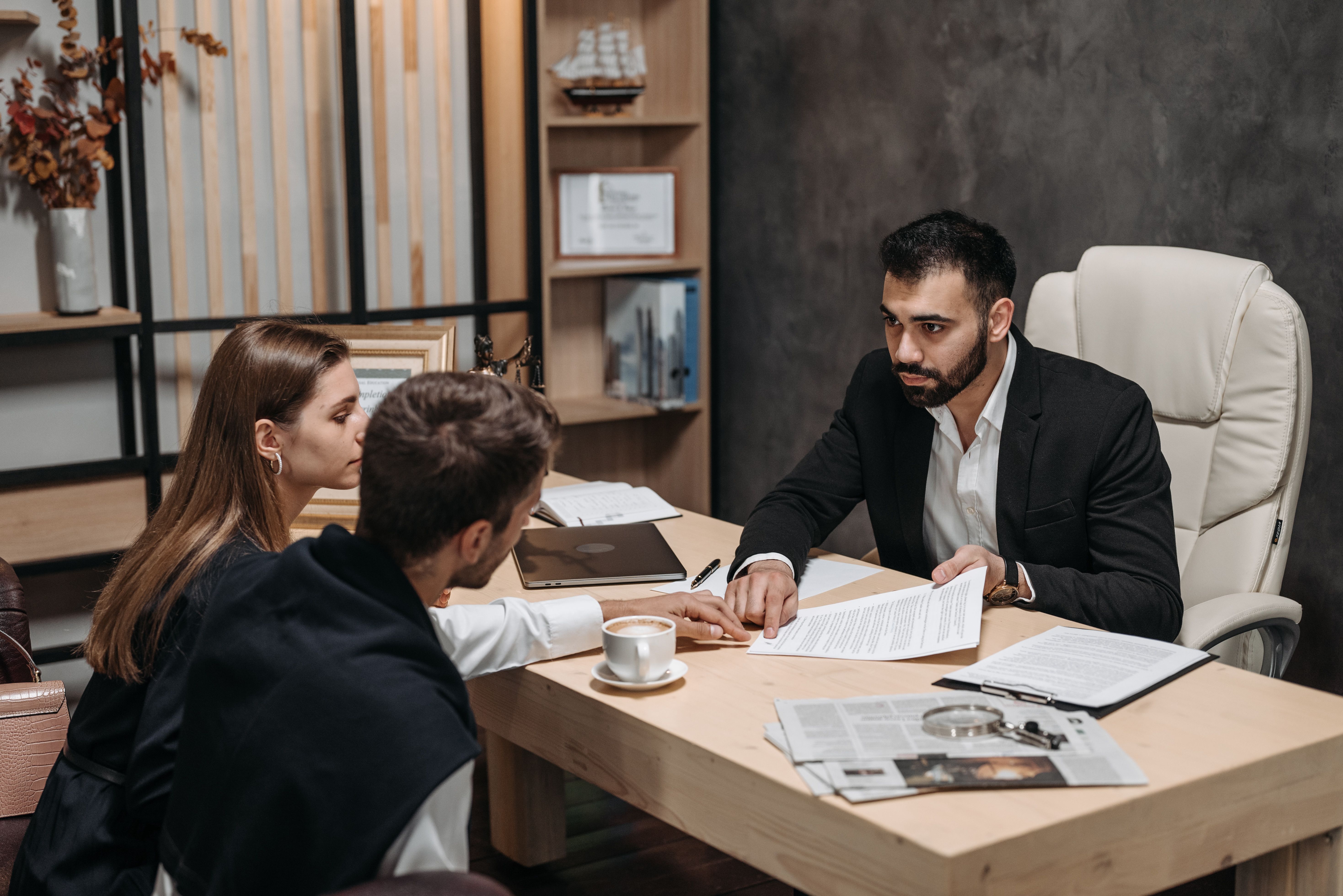 Lawyer discussing legal documents with clients at an office desk